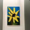 Das Bild „Crazy Flower“ von Newhardstyleart zeigt eine stilisierte, fast kindlich-energetische Darstellung einer gelben Blume, die an eine Sonnenblume erinnert. Die Blütenblätter sind leuchtend gelb, strahlen in alle Richtungen und wirken bewusst unregelmäßig gezeichnet, was dem Ganzen eine lebendige, „verrückte“ Ausstrahlung gibt. Die Mitte der Blume ist schwarz mit kleinen roten Punkten, was einen interessanten, fast pop-art-artigen Kontrast schafft. Der Hintergrund besteht aus einem klaren, kräftigen Blau für den Himmel und sattem Grün für die Landschaft. Der braune Stängel ragt aus dem unteren Bildbereich in die Blüte hinein. Der Malstil ist digital, mit breiten, weichen Pinselstrichen und kräftigen, ungemischten Farben. Das Gesamtbild wirkt fröhlich, verspielt und etwas unkonventionell – passend zum Titel „Crazy Flower“. Interpretativ könnte „Crazy Flower“ eine Feier der Individualität und Unangepasstheit sein. Die Blüte weicht deutlich von einer „perfekten“ Sonnenblumenform ab – ihre Blätter sind unterschiedlich lang, unregelmäßig angeordnet und strahlen fast wie in Bewegung. Das könnte symbolisieren, dass wahre Schönheit oft im Unperfekten, im Spontanen und im Eigensinn liegt. Die kräftigen Primärfarben – Gelb, Blau und Grün – vermitteln Freude, Optimismus und Energie. Die roten Punkte im dunklen Zentrum könnten als „kleine Funken“ interpretiert werden: Ideen, Emotionen oder Besonderheiten, die im Inneren schlummern und die Blume einzigartig machen. Insgesamt wirkt das Bild wie eine Hommage an das Anderssein: nicht streng geordnet, sondern wild, frei und lebendig – eben „crazy“.